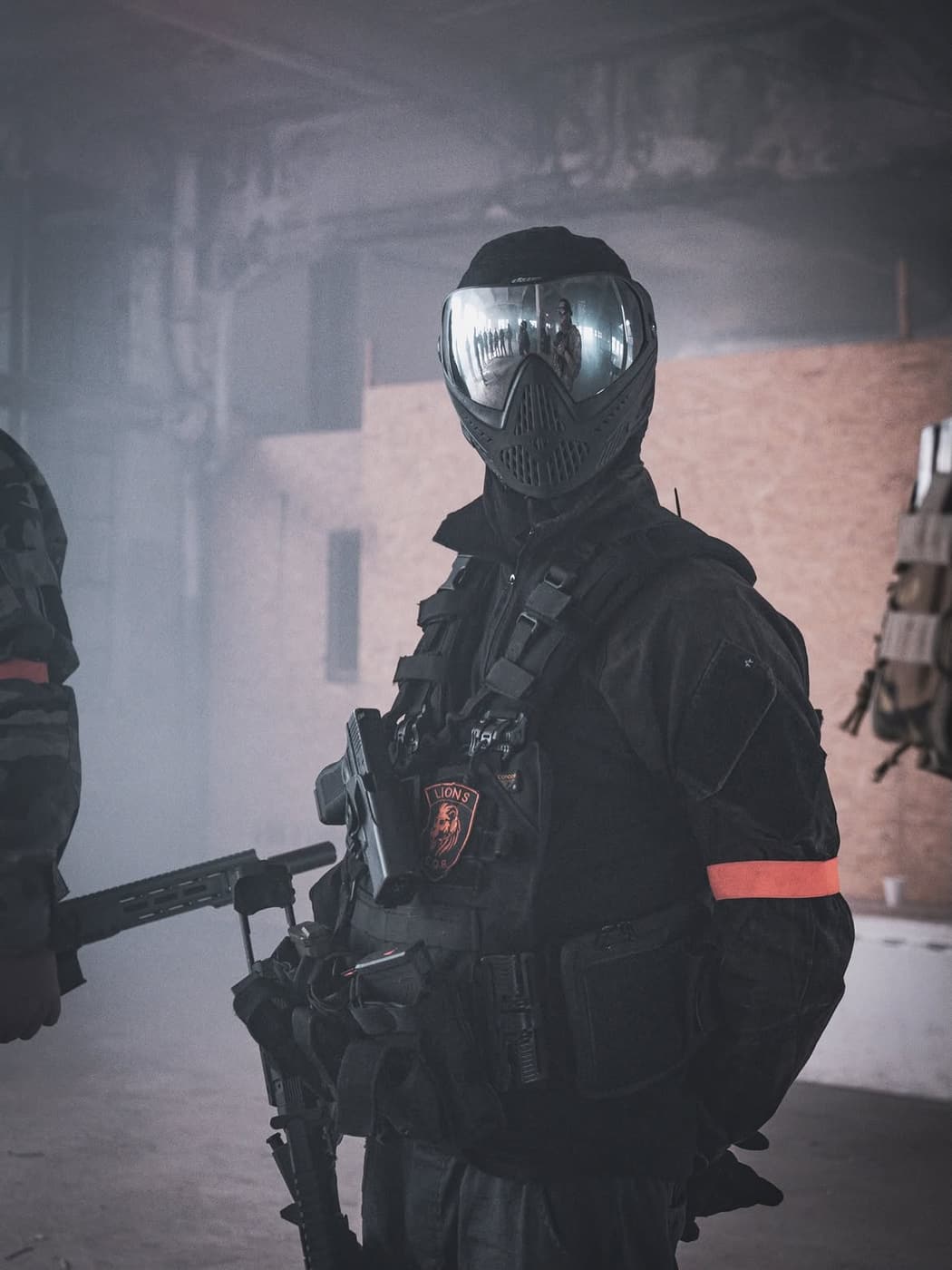 Jugador con máscara completa y espejo en el visor, entre el humo de una partida.